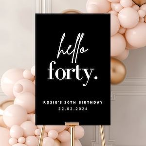May include: Black sign with white text that reads "hello forty."  The sign also includes the text "Rosie's 30th Birthday 22.02.2024".