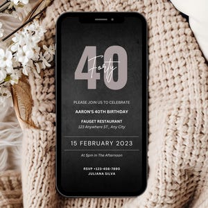 Op de afbeelding: Een smartphone toont een digitale uitnodiging voor Aarons 40e verjaardag. Het ontwerp toont het getal "40" in mauve, met het woord "Forty" in script. De uitnodiging bevat datum, tijd en RSVP-informatie op een donkergrijze achtergrond.