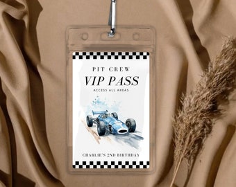 Op de afbeelding: Een witte VIP-pas met zwart-witte geruite randen. De pas heeft de tekst "PIT CREW VIP PASS ACCESS ALL AREAS" en een blauwe en witte illustratie van een raceauto. Onderaan de pas staat "CHARLIE'S 2ND BIRTHDAY".