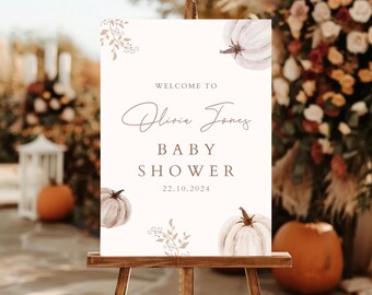 Könnte beinhalten: Willkommen zur Babyparty von Olivia Jones Schild mit weißem Hintergrund und braunem Text. Das Schild zeigt eine Aquarell-Illustration von Kürbissen und Blättern. Das Datum der Party ist der 22.10.2024.
