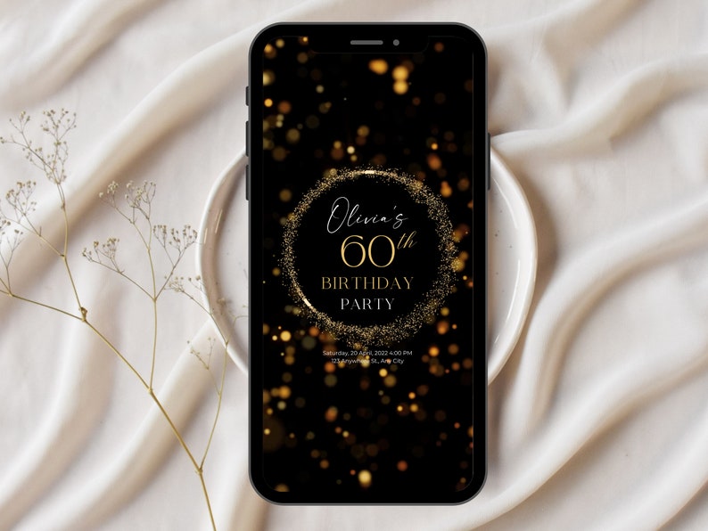 May include: A black mobile phone screen displaying a gold glitter birthday invitation for Olivia's 60th birthday party. The invitation has a gold circle with the text "Olivia's 60th Birthday Party" and a black background with gold glitter.
