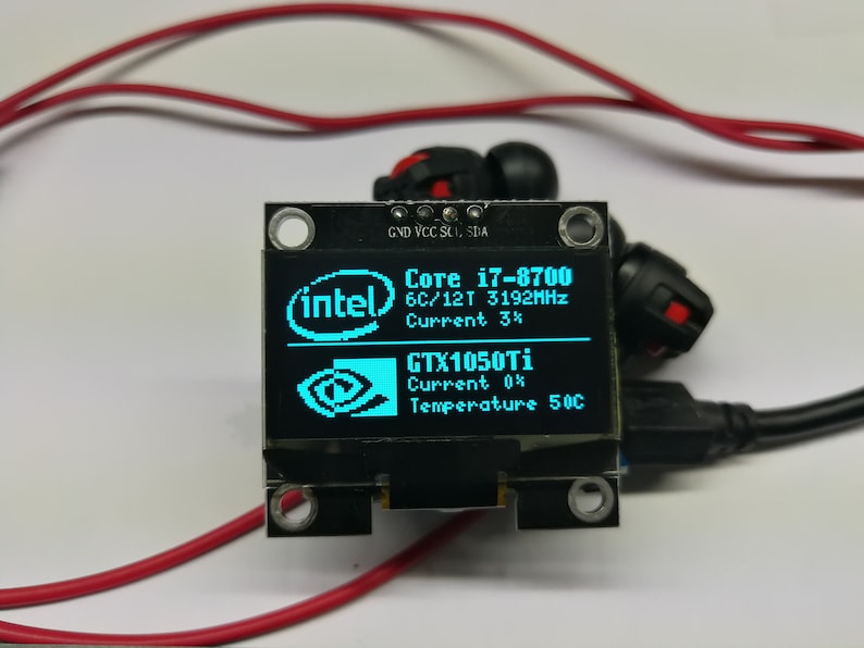 May include: A small blue LCD screen displays system information, including the text "Core i7-8700", "6C/12T 3192MHz", "Current 3%", "GTX1050Ti", "Current 0%", and "Temperature 50C". The screen is mounted on a black circuit board with four small black screws.