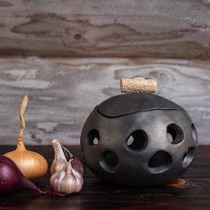 Porta-cebolas e alho artesanal em cerâmica preta, estilo nórdico.