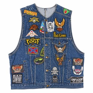 May include: A blue denim vest adorned with numerous embroidered patches. Patches feature eagles, skulls, and text like "Rolling Thunder" and "Bad Company." The vest has a button-up front and two front pockets, showcasing a vintage biker aesthetic.