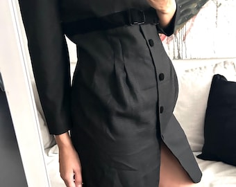 May include: A black dress with a velvet belt and a button closure. The dress has a fitted bodice and a slightly flared skirt. The dress is knee-length and has a slit on the side.