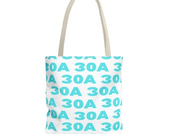 Puede incluir: Un bolso de tela blanco con un patrón repetitivo del texto 30A en un color azul cian brillante. El bolso tiene dos asas de tela de color beige claro resistentes unidas a la parte superior, ofreciendo un diseño simple y funcional.