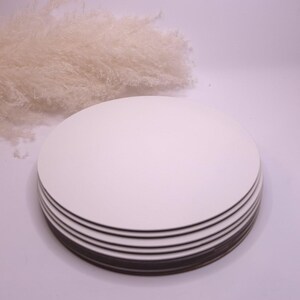 May include: A stack of six white round cake boards. The boards are made of sturdy cardboard and are perfect for supporting cakes and other desserts.