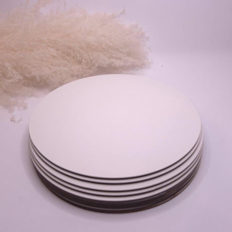 May include: A stack of six white round cake boards. The boards are made of sturdy cardboard and are perfect for supporting cakes and other desserts.