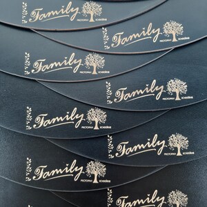 May include: A stack of black leather coasters with a gold-colored logo that says "Family" with a stylized tree and the words "Restaurant" and "Coffee Shop" in smaller font.