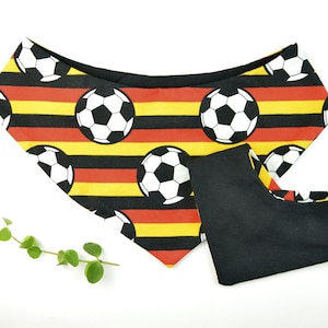 Könnte beinhalten: Ein schwarz-gelb gestreiftes Hundehalstuch mit einem Fußballmuster. Das Halstuch hat eine schwarze Stoffrückseite.