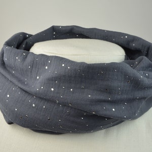 Könnte beinhalten: Ein grauer Infinity-Schal mit silbernen Glitzerpunkten.