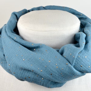 Könnte beinhalten: Ein blauer Infinity-Schal mit goldenen Glitzerpunkten. Der Schal ist aus einem weichen, bequemen Stoff gefertigt und perfekt, um jedem Outfit einen Hauch von Glamour zu verleihen.