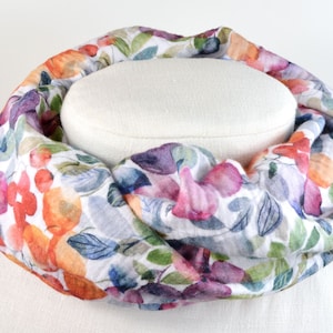 Könnte beinhalten: Ein weißer Schal mit einem Blumendruck mit orangefarbenen, rosa, violetten und grünen Aquarellblumen.