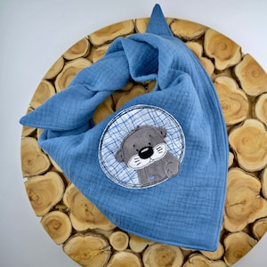 Könnte beinhalten: Ein blaues Bandana mit einem weißen und blauen karierten Kreis, der eine gestickte graue Otter mit schwarzer Nase und Schnurrhaaren zeigt.
