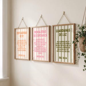 Peut inclure: Trois impressions encadrées avec du texte en espagnol. Chaque impression est suspendue par une chaîne et possède un cadre en bois. Les impressions présentent des rayures verticales roses, vertes et beiges, avec du texte de couleurs assorties.