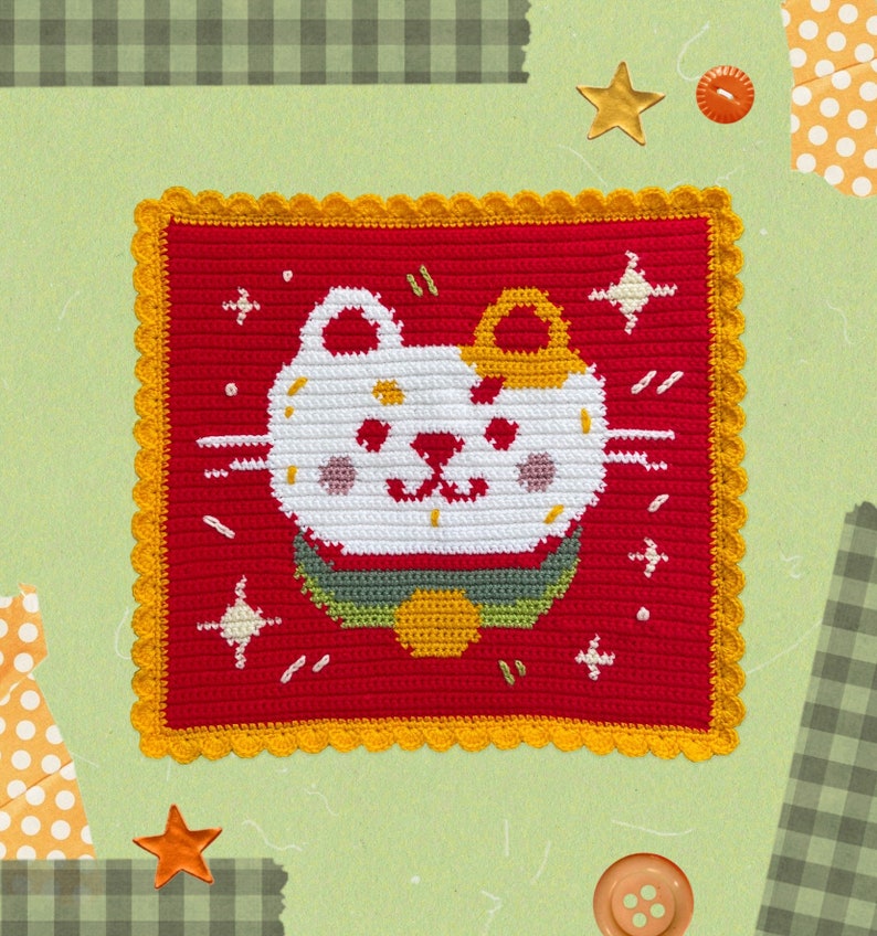 May include: A red crocheted square with a yellow border features a white cat with a yellow crown and a green and yellow bow tie. The cat is surrounded by white stars.