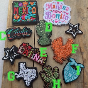 May include: A collection of embroidered patches featuring various designs including the text MEXICO, Mañana sera Bonito, Chula, and LATINA, alongside shapes like a cactus, a star, a rooster, the state of Texas with roses, and a turquoise bandana.