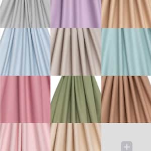 Pu&ograve; includere: Una griglia di campioni di tessuto in vari colori uniti. I colori includono grigio chiaro, lavanda, beige, azzurro, beige, turchese, rosa, verde oliva e marrone. Il tessuto &egrave; drappeggiato, mostrando la trama e le pieghe.