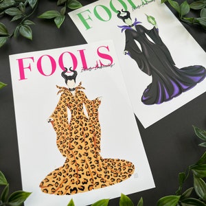 May include: Two printable art prints featuring the Disney villain Maleficent. The first print features Maleficent in a black and purple gown with a green staff. The second print features Maleficent in a leopard print gown. Both prints have the word "FOOLS" in large letters at the top and the text "Fools - Imbeciles!" below the image.