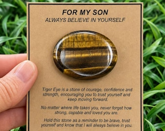 May include: A polished oval tiger eye stone attached to a tan card with the text FOR MY SON ALWAYS BELIEVE IN YOURSELF. The card includes a printed message about courage and strength, ending with the website address ccshealingcrystals.etsy.com.