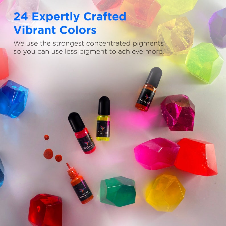 May include: 24 bottles of concentrated pigment in various colors, labeled "ROLIO". The bottles are arranged on a white surface with colorful, translucent, geometric shapes.