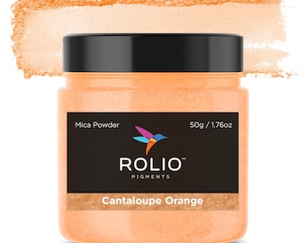 May include: A round jar of Cantaloupe Orange mica powder, labeled "Rolio Pigments" with a hummingbird logo. The jar is 50g / 1.76oz and is sitting on a white background.