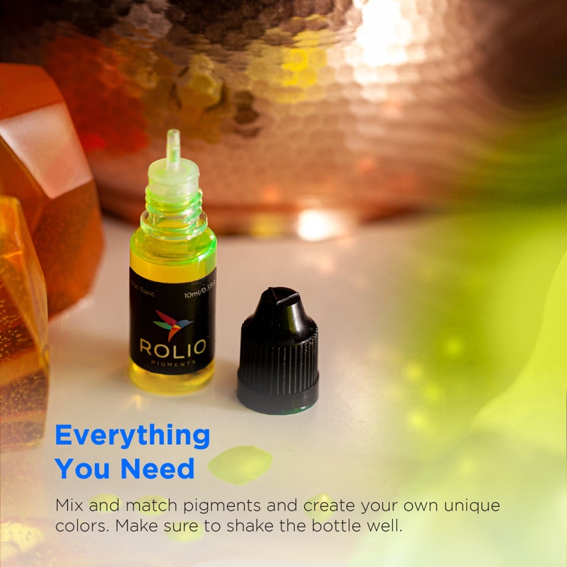 May include: Two small bottles of green liquid with black caps. The bottle on the left has a label that says "ROLIO PIGMENTS". The text "Everything You Need" is written in blue and yellow on a white background.