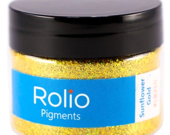 Puede incluir: Un tarro de purpurina Rolio Pigments Sunflower Gold. El tarro es transparente y muestra la purpurina dorada en el interior. La etiqueta es azul con texto blanco.