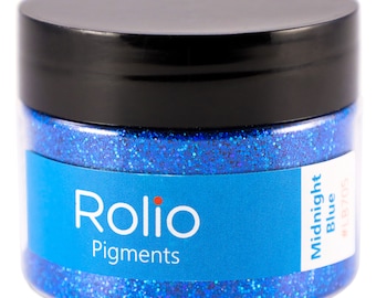 Puede incluir: Un frasco transparente lleno de purpurina azul. El frasco tiene una tapa negra y una etiqueta que dice "Rolio Pigments" y "Midnight Blue #LB705".
