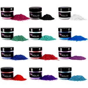 May include: Twelve small jars of pigment powder in various colors, including red, blue, green, black, and white. Each jar has a black lid and a label that reads "ROLIO PIGMENTS".