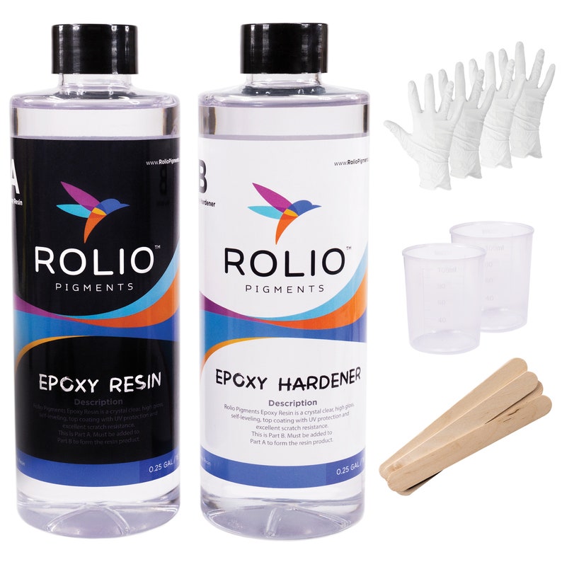 May include: Two clear plastic bottles with black lids and labels. The bottles are labeled "Rolio Pigments Epoxy Resin" and "Rolio Pigments Epoxy Hardener". The bottles are sitting on a white surface. There are also two clear plastic measuring cups, three wooden mixing sticks, and five white disposable gloves.