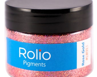 Puede incluir: Un tarro de purpurina Rose Gold de Rolio Pigments. El tarro está lleno de purpurina fina e iridiscente que brilla a la luz.