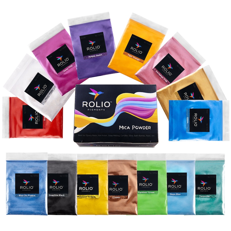 May include: A set of 14 mica powder pigments in a variety of colours, including white, red, purple, orange, pink, gold, blue, green, yellow, black, copper, and turquoise. The pigments are packaged in small clear plastic bags with the brand name "ROLIO" printed on them. The bags are arranged in two rows on a white background. The product is labelled "MICA POWDER" and is marketed as being suitable for use in epoxy resin, nail polish, soap making, candles, slime, bath bombs, paint, and art.