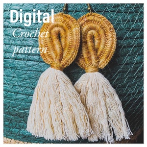 May include: A pair of crocheted earrings with gold and brown tassels. The earrings are made with a thick yarn and have a unique, textured design. The text "Digital Crochet pattern" is visible in the image.