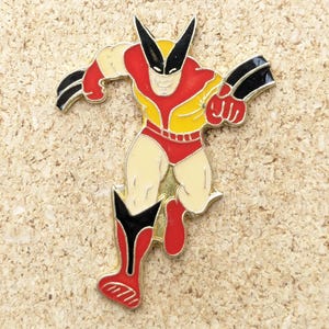 Peut inclure: Une épingle en émail jaune, rouge et noire représentant un dessin animé de Wolverine, un super-héros populaire de Marvel Comics.