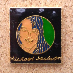 K&ouml;nnte beinhalten: Eine goldfarbene Anstecknadel mit schwarzem Hintergrund und einem runden Bild von Michael Jackson. Das Bild ist von einem blauen und gr&uuml;nen Rand umgeben. Der Text "Michael Jackson" ist in Gold unter dem Bild geschrieben.