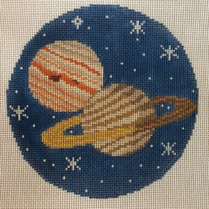 May include: A needlepoint canvas with a blue background depicting a stylized image of two planets, one with rings, in a starry night sky.