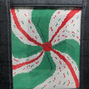 Puede incluir: Un diseño de bastón de caramelo verde, blanco y rojo sobre un lienzo blanco. El diseño es un remolino de colores y está enmarcado en negro.