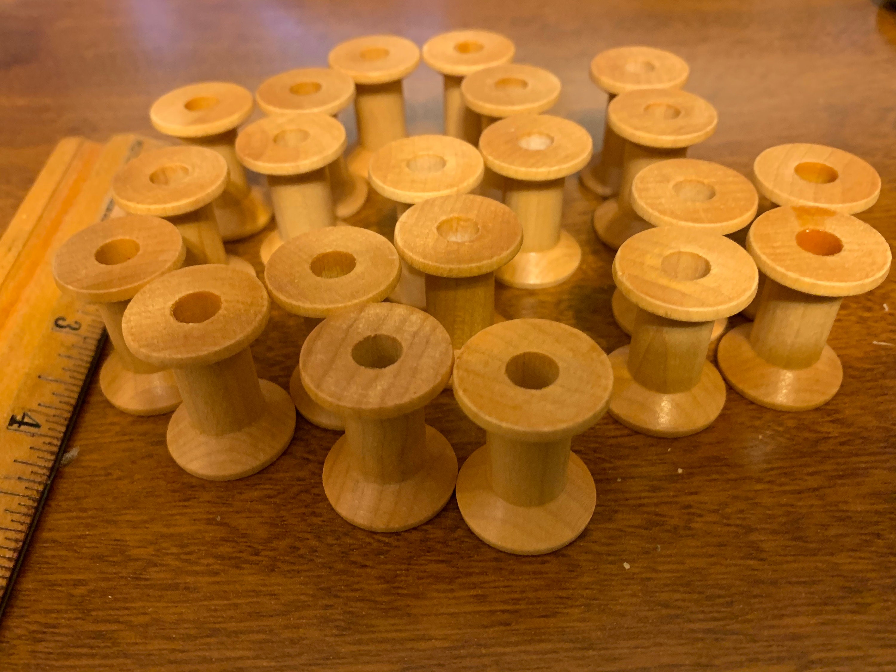 21 Wooden Spools 1 1/8 Inch Tall, Base is 3/4 Inch, and Hole is 1/4 Inch. 