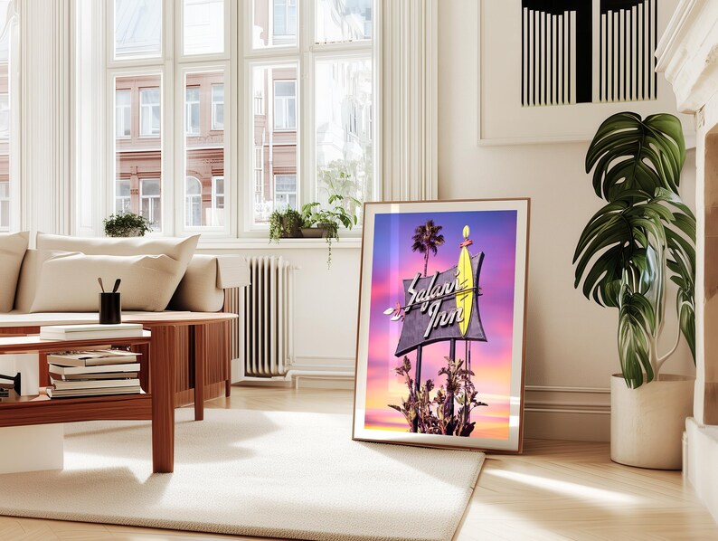 K&ouml;nnte beinhalten: Ein Vintage-Motel-Schild mit einem Surfbrett und den Worten "Salami Inn" in pinken und wei&szlig;en Neonbuchstaben vor einem lila und rosa Sonnenuntergang.
