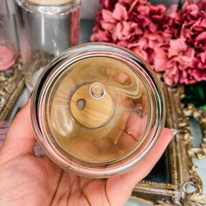 Peut inclure: Un bocal en verre transparent avec un couvercle en bois. Le bocal est vide et a un petit trou au fond.