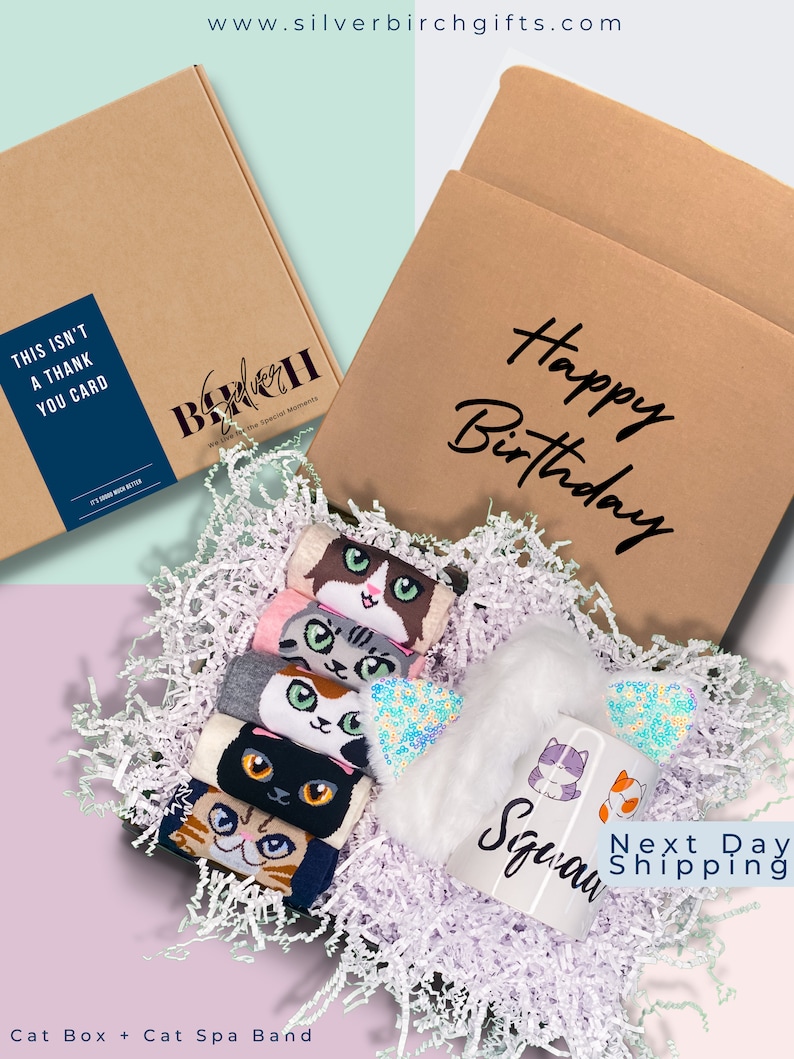 May include: A brown cardboard box with the text "Happy Birthday" on the front. The box is filled with white tissue paper and contains a set of six cat-themed socks and a white mug with the text "Meow" and cat illustrations. The box is labeled with the text "This isn't a thank you card" and "Silver Birch for the special moments".