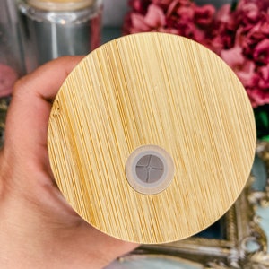 Peut inclure: Un couvercle rond en bois de couleur brun clair avec un centre gris l&eacute;g&egrave;rement sur&eacute;lev&eacute;. Le couvercle a une texture de grain de bois.