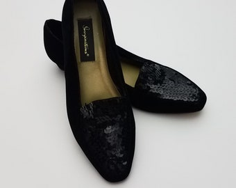May include: Black suede flats with a pointed toe and a sequined design. The shoes have a gold label that reads "Seychelles".
