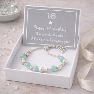 May include: A silver bracelet with turquoise beads and silver accents, presented in a white gift box. The card reads "Happy 16th Birthday, Treasure this bracelet, A bead for each amazing year."