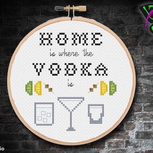 May include: White embroidery hoop with the text "HOME is where the VODKA is" in black.  Two lemon and lime wedges with green olives are on either side of the text.  A martini glass and two shot glasses are below the text.