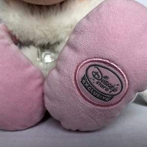 May include: Pink plush toy with a white fur collar and a Disney Store Exclusive tag on one foot.