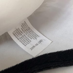 May include: White fabric label with black text that reads "SURFACE WASHABLE SUPERFICIE LAVABILE BUPERFICIE LAVABLE SUPERFICIE LAVAVEL LAVABLE EN SURFACE MADE IN CHINA PRODOTTO IN CINA PABRICADO EN CHINA FABRIQUE EN CHINE CABRIGADO EM CHINA 2009-06-29D"