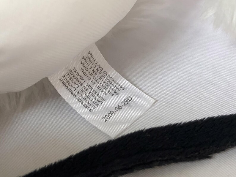 May include: White fabric label with black text that reads "SURFACE WASHABLE SUPERFICIE LAVABILE BUPERFICIE LAVABLE SUPERFICIE LAVAVEL LAVABLE EN SURFACE MADE IN CHINA PRODOTTO IN CINA PABRICADO EN CHINA FABRIQUE EN CHINE CABRIGADO EM CHINA 2009-06-29D"