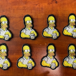 Puede incluir: Ocho parches de planchado de color amarillo con un personaje de dibujos animados. Cada parche muestra un personaje sosteniendo una jarra de cerveza. El personaje lleva una camisa blanca y tiene una cara amarilla con cabello castaño y bigote.